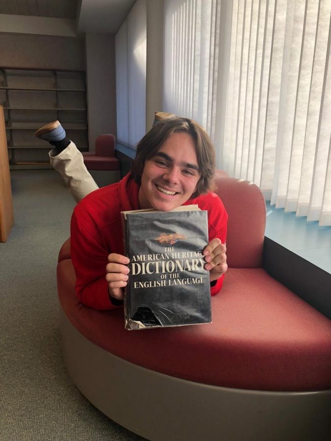 Nolan Wollum poses with a dictionary for his annual slang article.