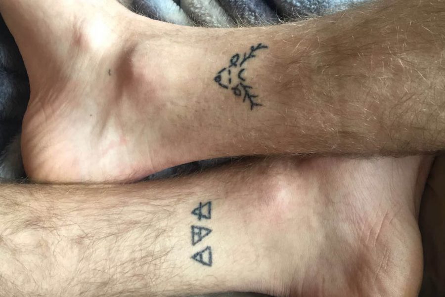 Two ankle tattoos; one of a deer, another of triangles.