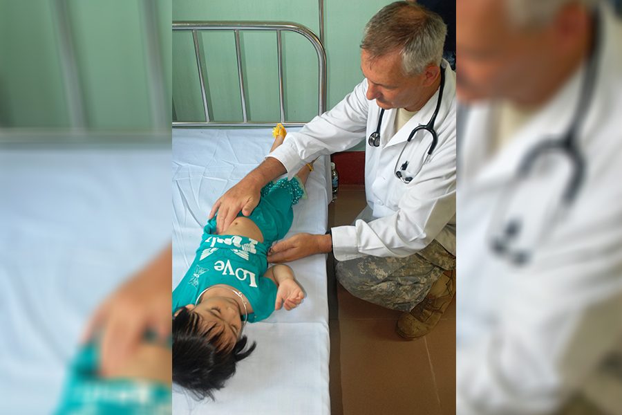 Doctor helps a child patient, location and name of either unknown.