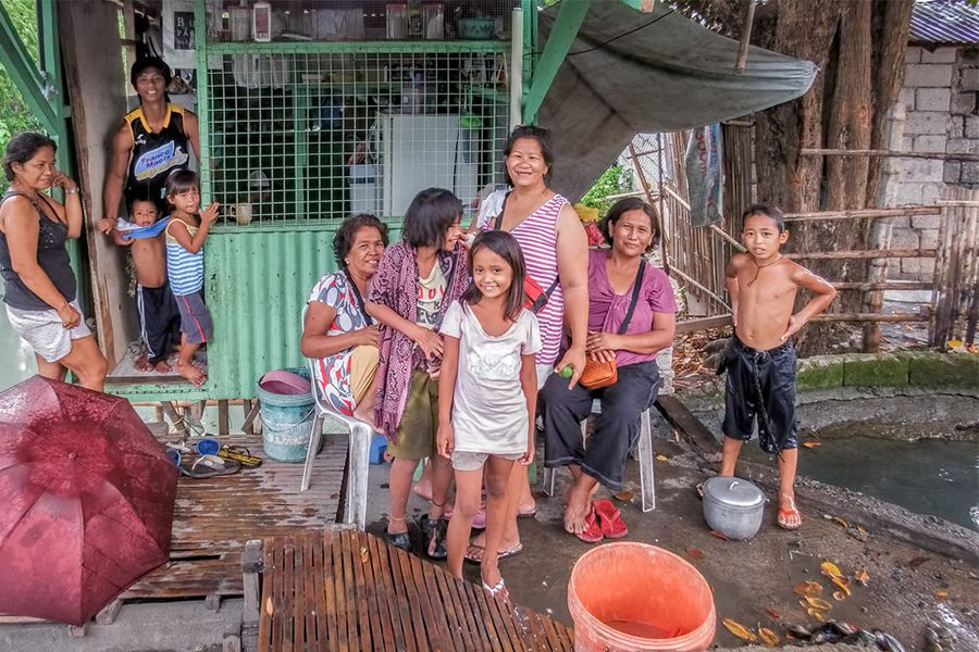 A family in Thailand stays outside of their makeshift home, location unknown.
