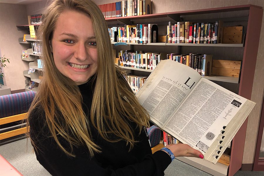 Journalist, Lauren Lindmeier, poses with a dictionary. 
