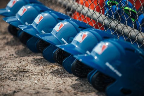 Image shows helmet lined up against the fence as MLB Players await the season to re-open