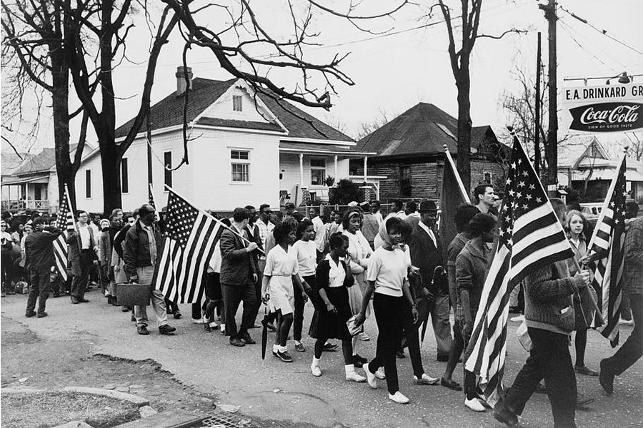 African Americans marching through the streets peacefully protesting for their rights.