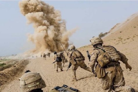 American soldiers move for cover as a terrorist explosion is unleashed on their path