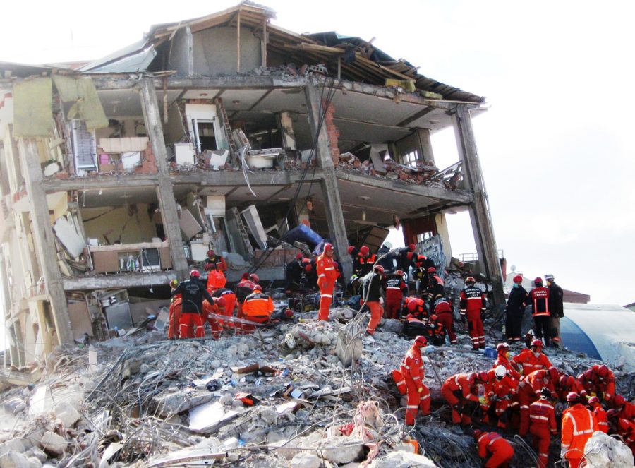 Rescue workers help civilians evacuate their homes that have been destroyed.