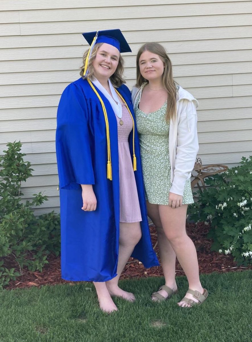 Before commencement in 2022, Erin and her sister, Brenna, take a photo in Brennas cap and gown, prepared for graduation.