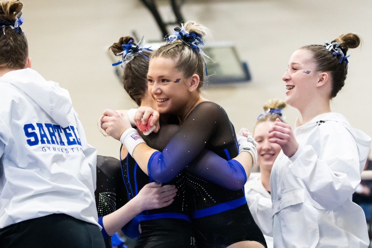 Elizabeth Jarnot hugs her teammate, Kendra Deragisch at a gymnastics meet during their senior season. 