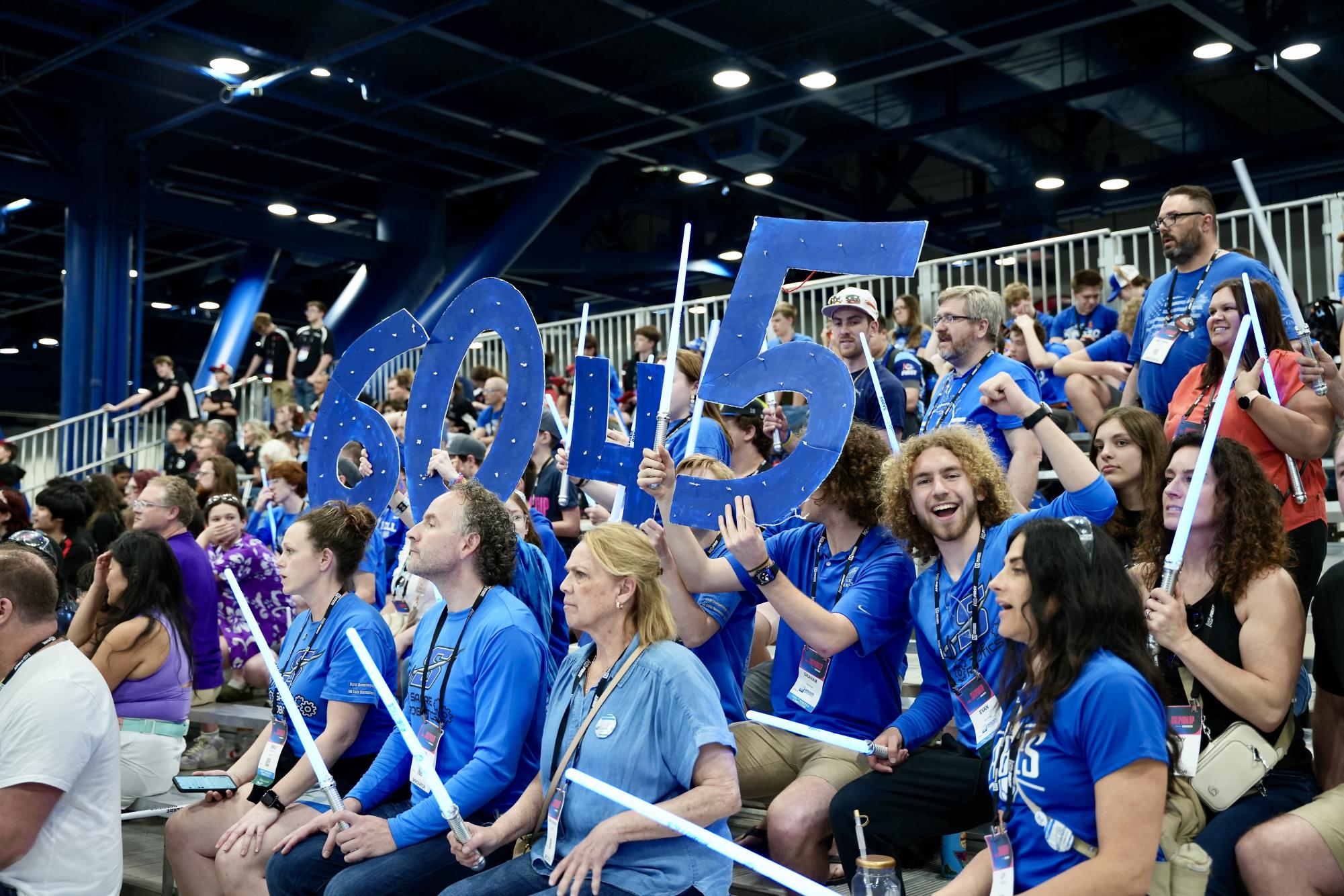 Families are some of the robotics team biggest supporters, they went as far as to buy blue glow up lightsabers to light up the stands in support of the team! (Photo used with permission from the 6045 Sabre Robotics Team)