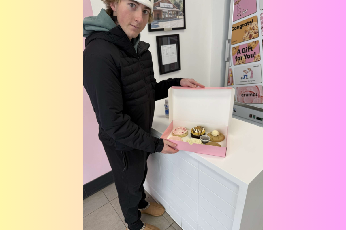 Jace happily receives this week's Crumbl cookies from a considerate employee.