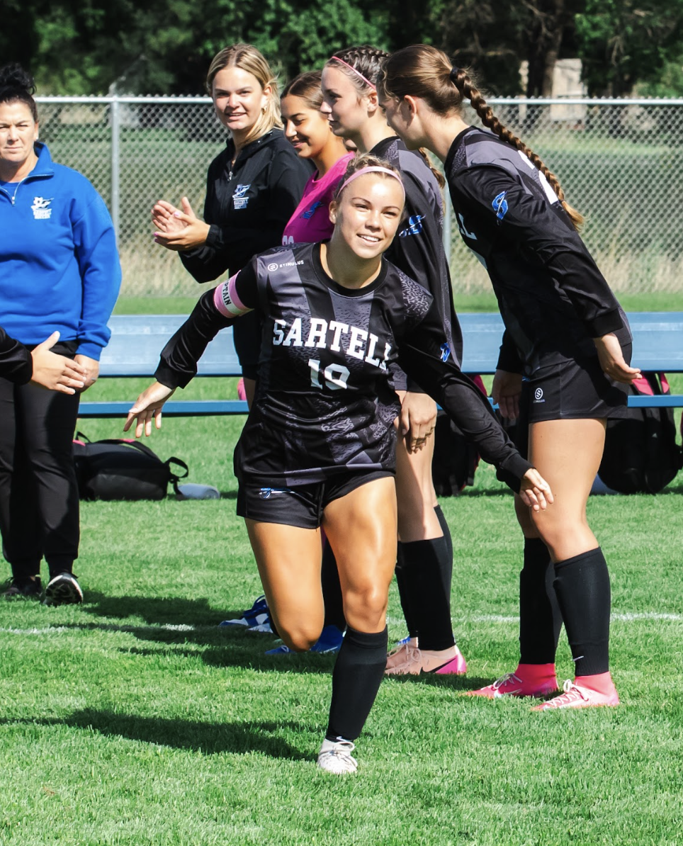 Caitlyn Valdez runs out through teammates to start the game. (Photo used with permission from Caitlyn Valdez).