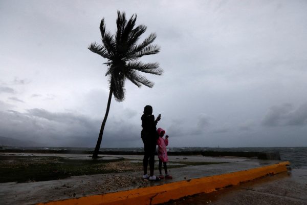A woman and a child stand along the Kingston waterfront as Hurricane Melissa approaches, in Kingston, Jamaica, October 27, 2025.  REUTERS/Octavio Jones