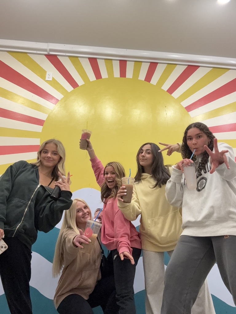 All of us happy after we got our drinks, in front of the vibrant wall.